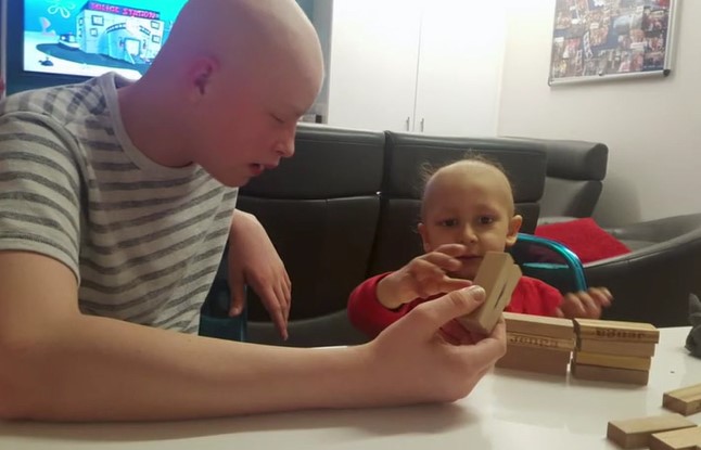 Harri plays with a child in hospital
