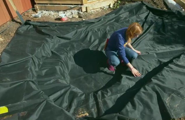 Katie lays the pond lining